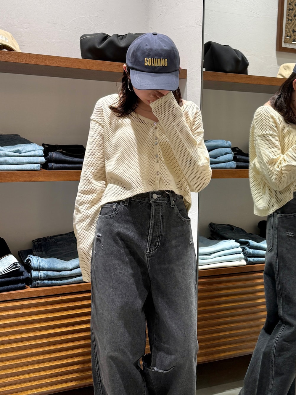 ブラック系のデニムパンツ、ブラック系のサンダル、ホワイト系のカーディガン/ボレロを着用したレディースの春コーディネートの5枚目の写真