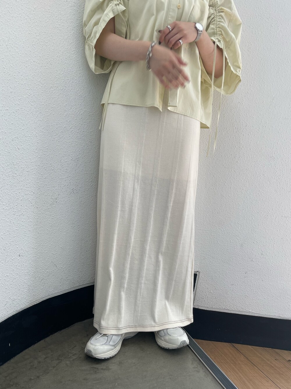 イエロー系のシャツ/ブラウス、ホワイト系のキャミソール、ホワイト系のスカートを着用したレディースの春コーディネートの8枚目の写真