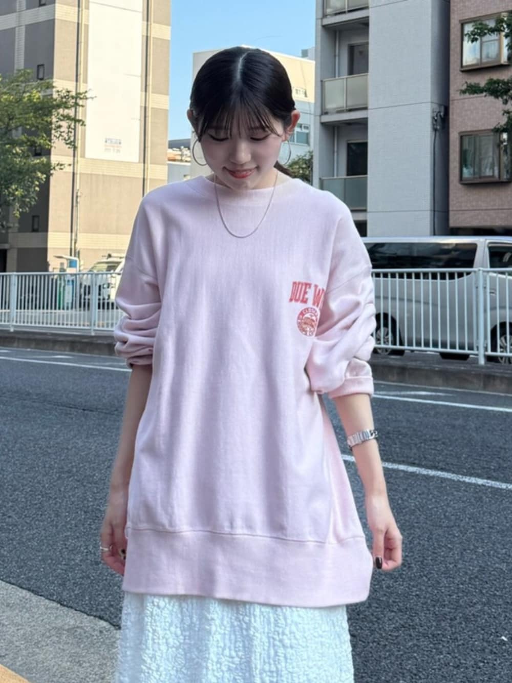 ホワイト系のスカート、ピンク系のスウェットを着用したレディースの秋コーディネートの5枚目の写真