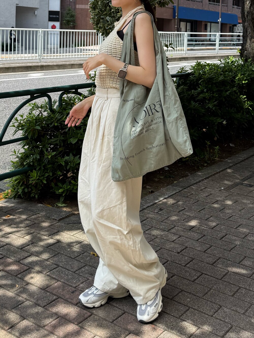 ホワイト系のチノパンツ、グリーン系のトートバッグ、ホワイト系のタンクトップを着用したレディースの夏コーディネートの4枚目の写真