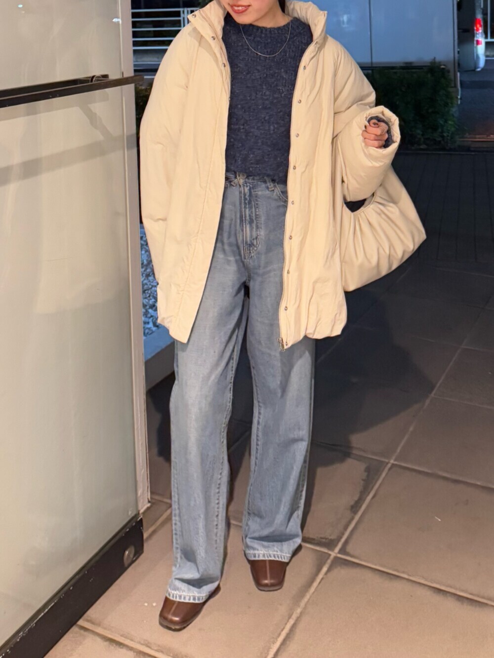 ブラウン系のブーツ、ブルー系のデニムパンツ、ホワイト系のブルゾンを着用したレディースの冬コーディネートの5枚目の写真