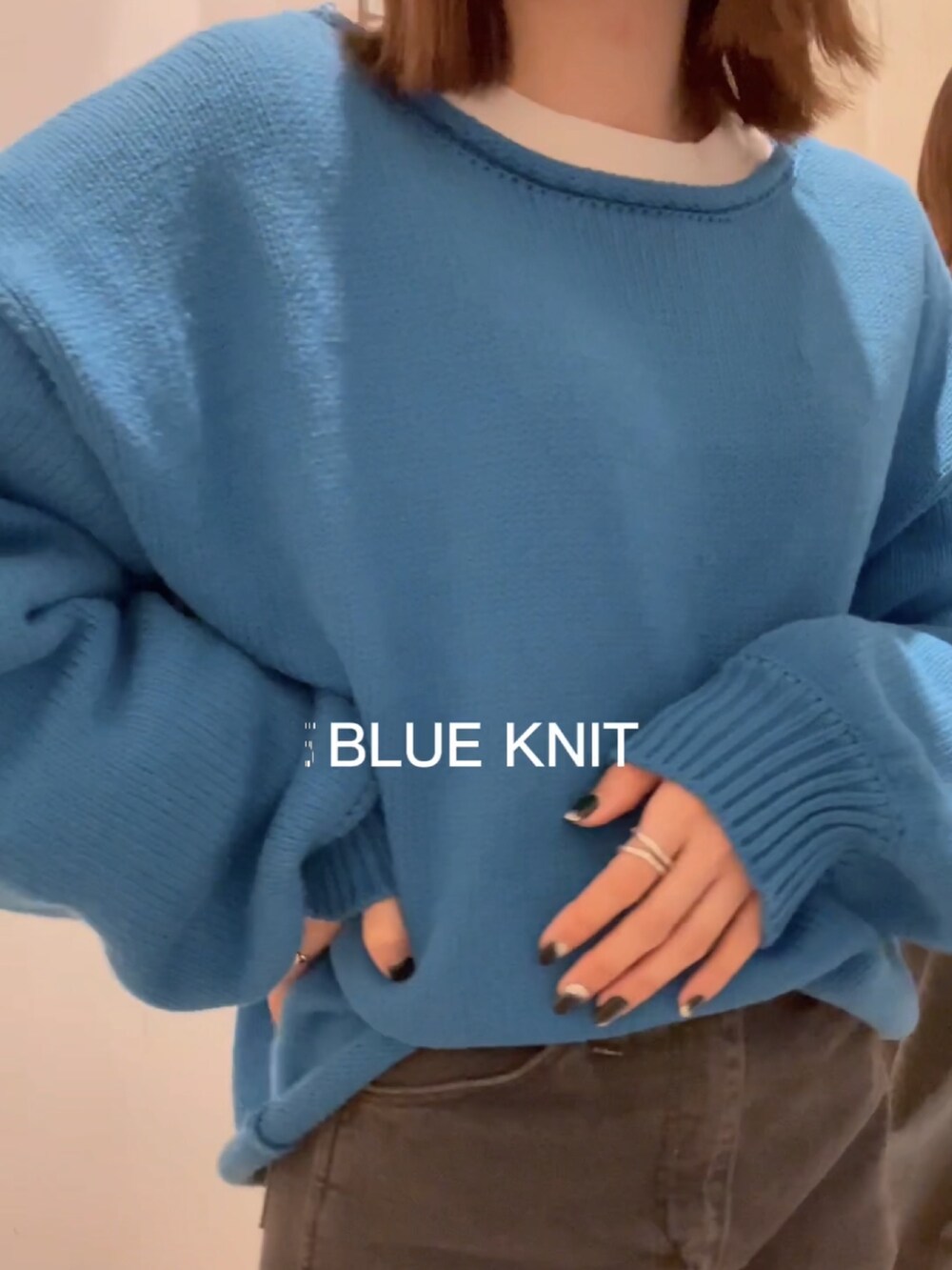 ブラック系のデニムパンツ、ブルー系のニット/セーター、ホワイト系のTシャツ/カットソーを着用したレディースの秋コーディネートの3枚目の写真