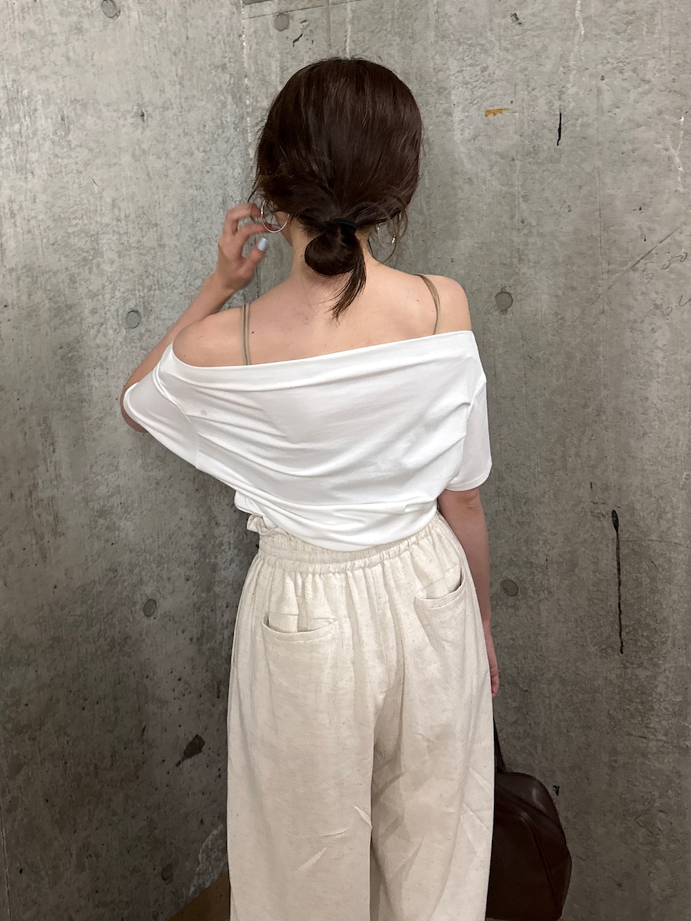 ホワイト系のその他パンツ、ホワイト系のTシャツ/カットソー、ブラウン系のハンドバッグを着用したレディースの夏コーディネートの3枚目の写真