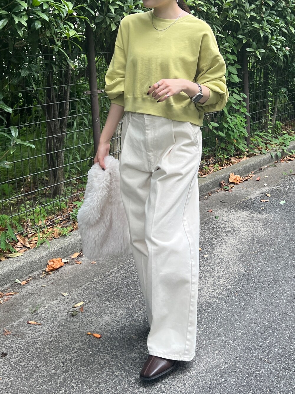 ホワイト系のデニムパンツ、ブラウン系のブーツ、グリーン系のスウェットを着用したレディースの秋コーディネートの5枚目の写真
