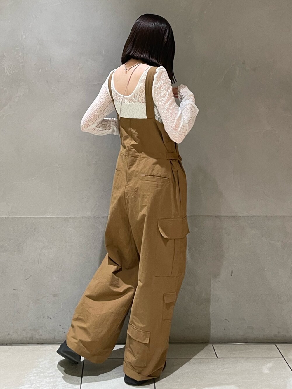 ホワイト系のTシャツ/カットソー、ブラック系のブーツ、シルバー系のショルダーバッグを着用したレディースの冬コーディネートの8枚目の写真