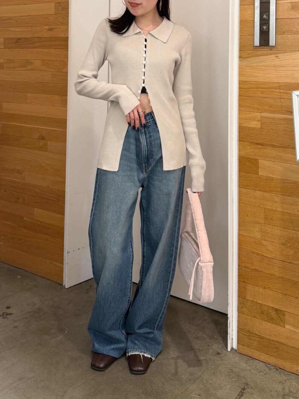 ブラウン系のブーツ、ブルー系のデニムパンツ、ピンク系のハンドバッグを着用したレディースの秋コーディネートの4枚目の写真