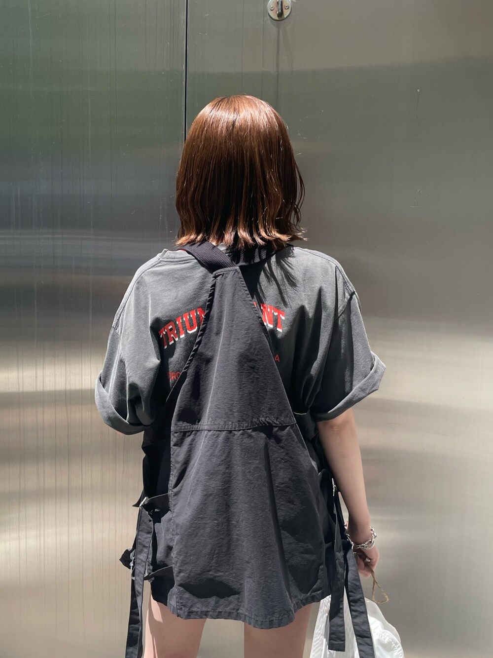 グレー系のTシャツ/カットソー、ブラック系のベスト、ホワイト系のハットを着用したレディースの春コーディネートの6枚目の写真