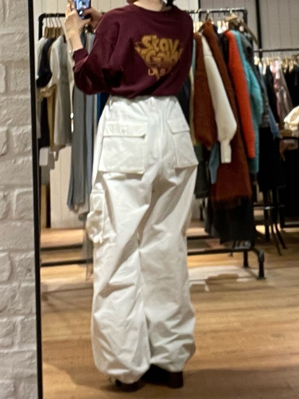 ブラック系のブーツ、ホワイト系のカーゴパンツ、レッド系のTシャツ/カットソーを着用したレディースの秋コーディネートの4枚目の写真