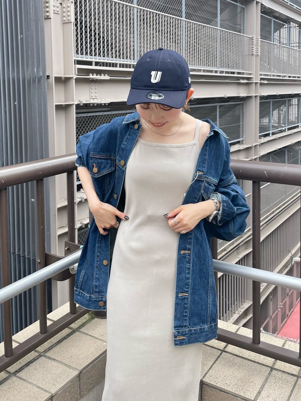 グレー系のワンピース、ブルー系のデニムジャケット、ブルー系のキャップを着用したレディースの夏コーディネートの10枚目の写真
