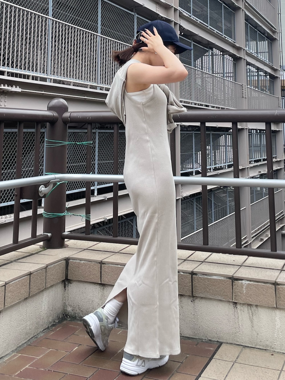 グレー系のワンピース、ブルー系のデニムジャケット、ブルー系のキャップを着用したレディースの夏コーディネートの5枚目の写真