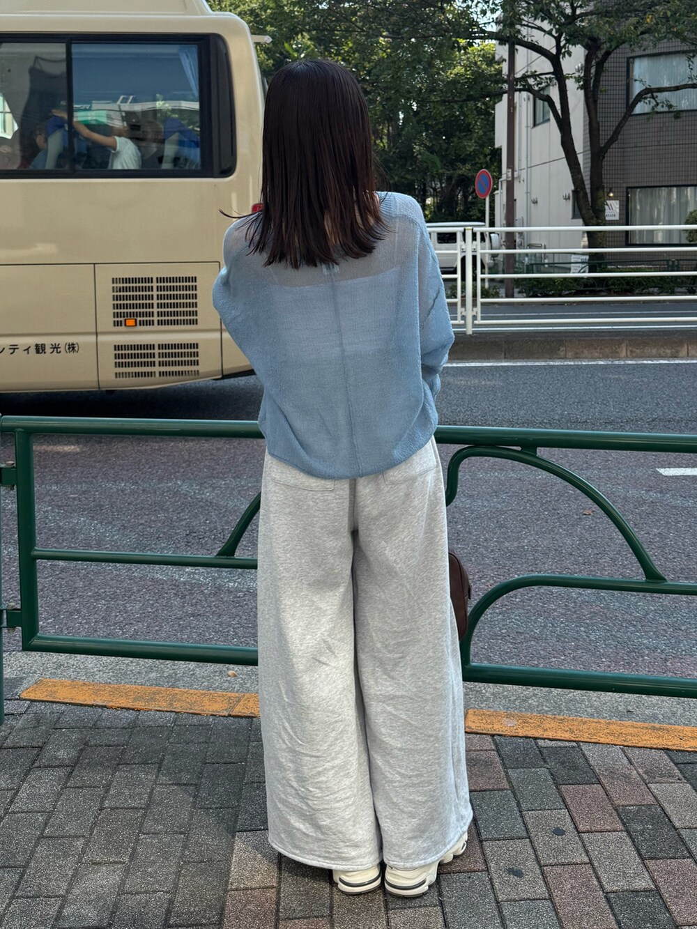 ブルー系のニット/セーター、ブラウン系のハンドバッグを着用したレディースの秋コーディネートの4枚目の写真