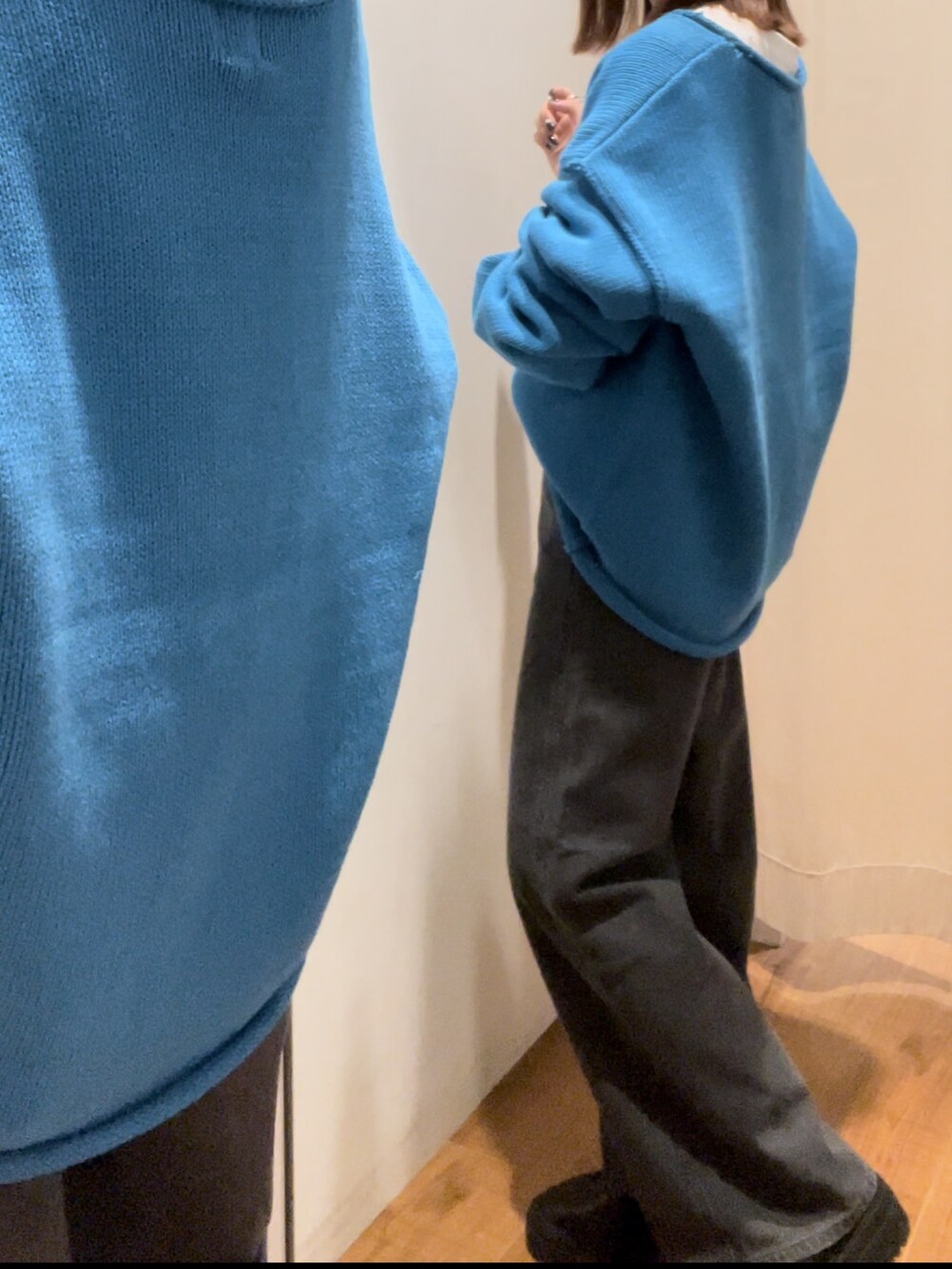 ブラック系のデニムパンツ、ブルー系のニット/セーター、ホワイト系のTシャツ/カットソーを着用したレディースの秋コーディネートの4枚目の写真