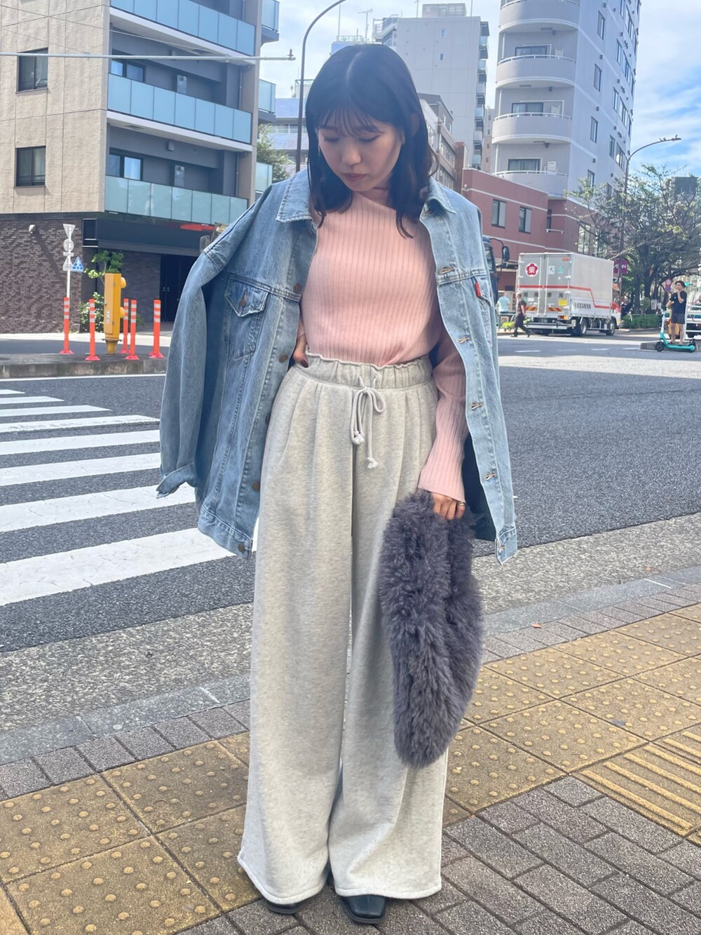 ピンク系のニット/セーター、グレー系のハンドバッグ、グレー系のスウェットパンツを着用したレディースの秋コーディネートの2枚目の写真