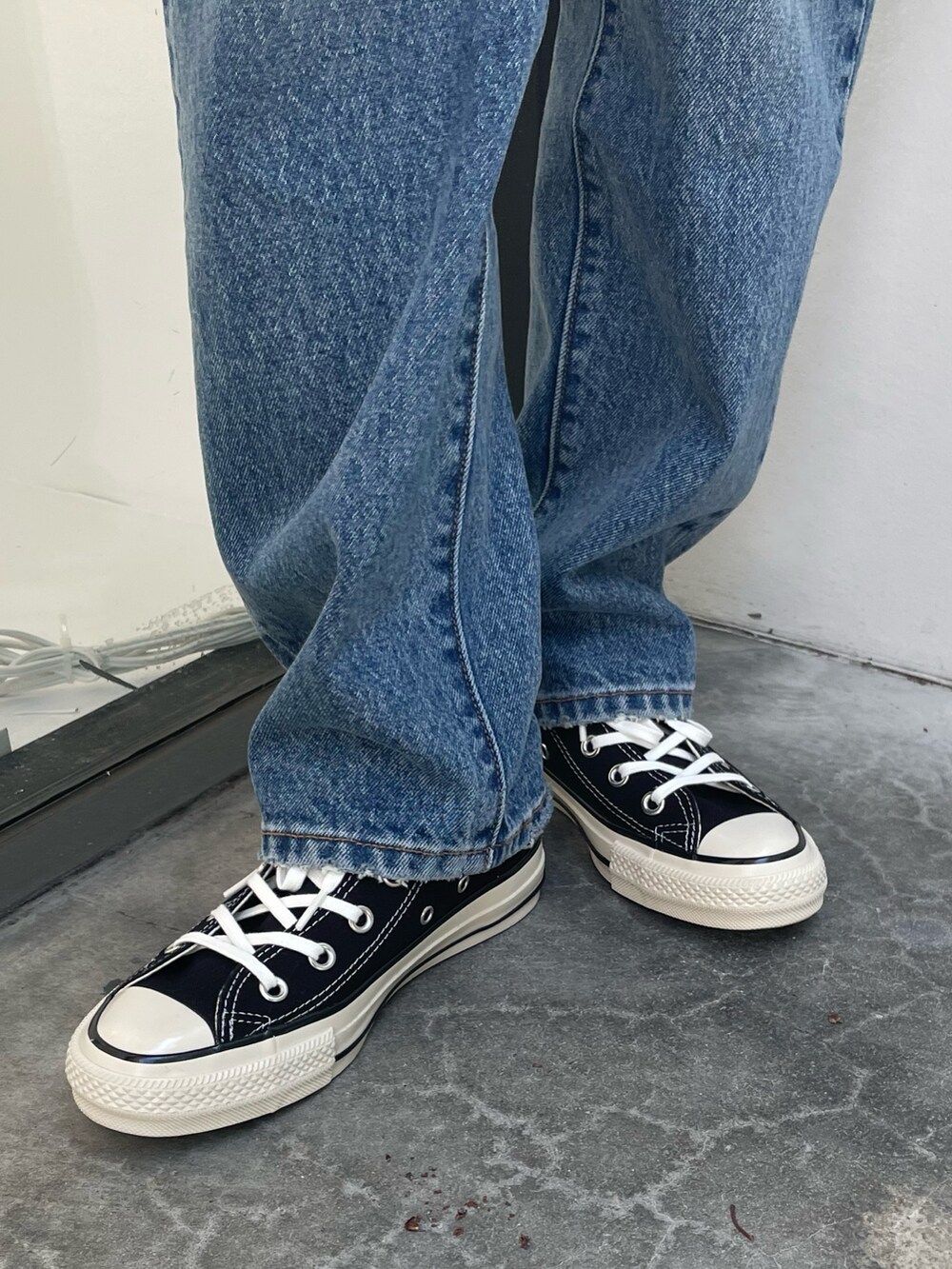 ホワイト系のシャツ/ブラウス、ブラック系のスニーカー、ブルー系のデニムパンツを着用したレディースの夏コーディネートの7枚目の写真