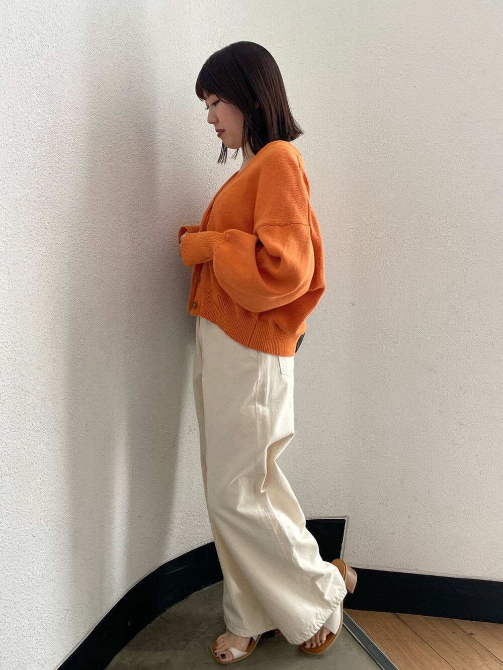 グレー系のキャミソール、ホワイト系のデニムパンツ、ホワイト系のサンダルを着用したレディースの春コーディネートの5枚目の写真