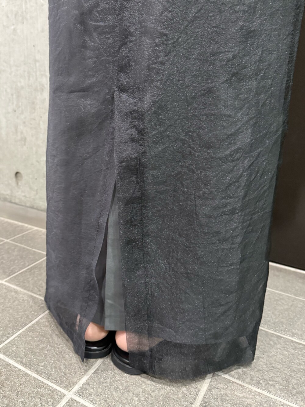 グレー系のスカート、グリーン系のタンクトップ、ブラック系のサンダルを着用したレディースの夏コーディネートの9枚目の写真