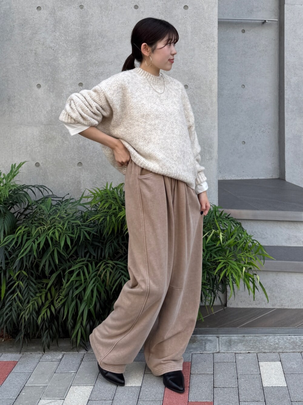 ベージュ系のスウェットパンツ、ブラック系のブーツ、ホワイト系のTシャツ/カットソーを着用したレディースの秋コーディネートの3枚目の写真