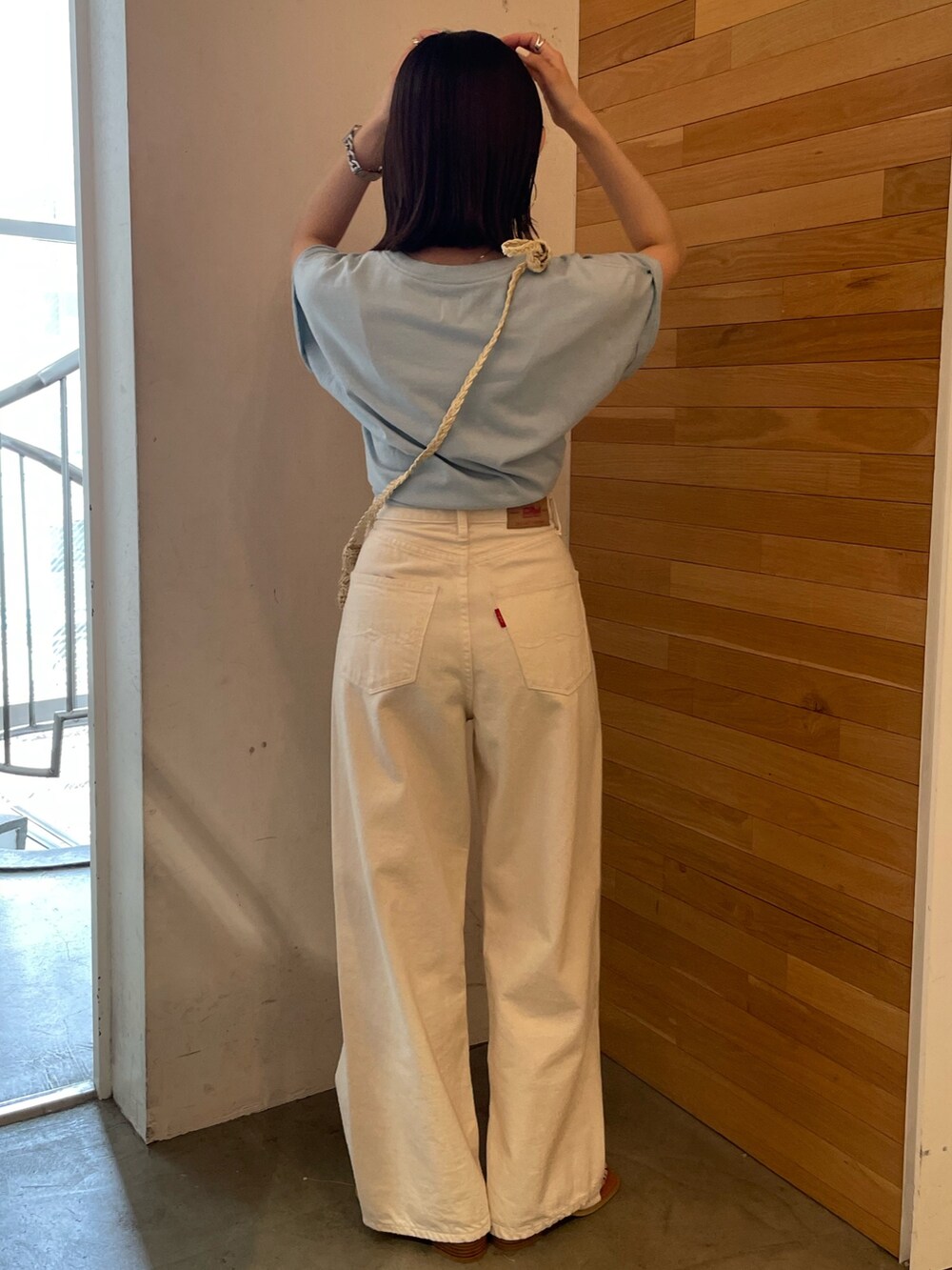 ブルー系のTシャツ/カットソー、ホワイト系のサンダル、ベージュ系のショルダーバッグを着用したレディースの春コーディネートの3枚目の写真