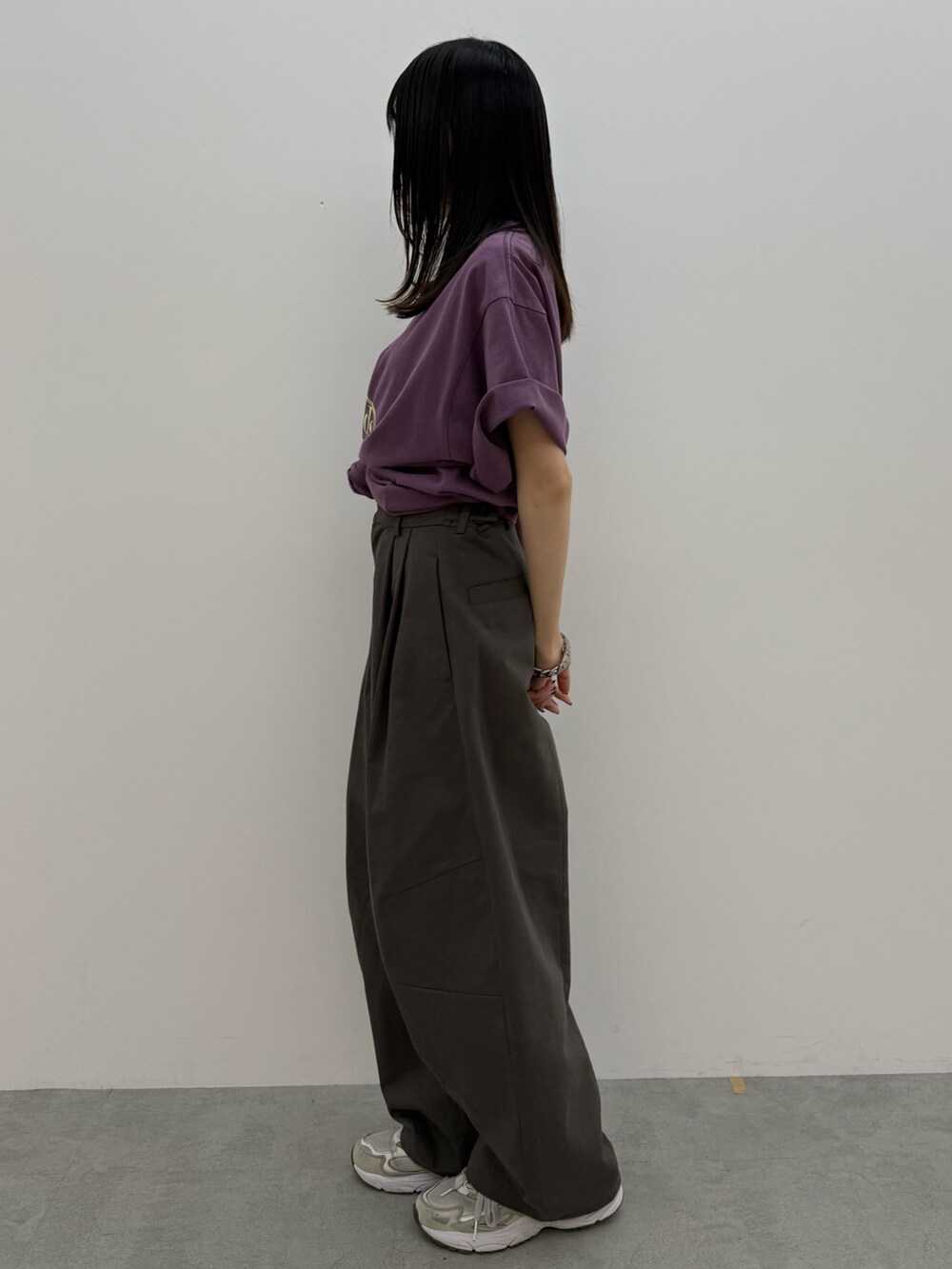 グレー系のチノパンツ、パープル系のTシャツ/カットソーを着用したレディースの春コーディネートの3枚目の写真