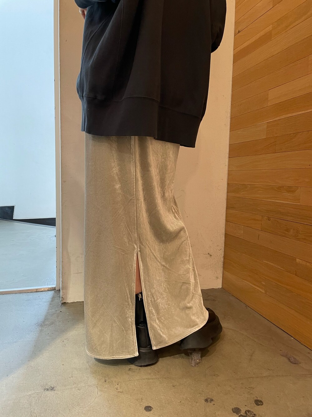 グレー系のスカート、ブラック系のブーツ、ブルー系のTシャツ/カットソーを着用したレディースの秋コーディネートの7枚目の写真