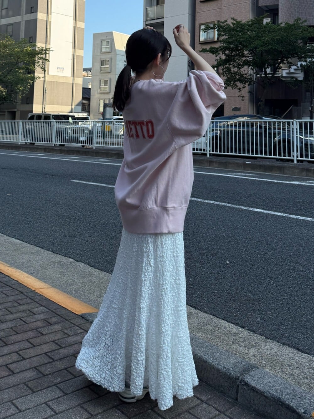 ホワイト系のスカート、ピンク系のスウェットを着用したレディースの秋コーディネートの3枚目の写真