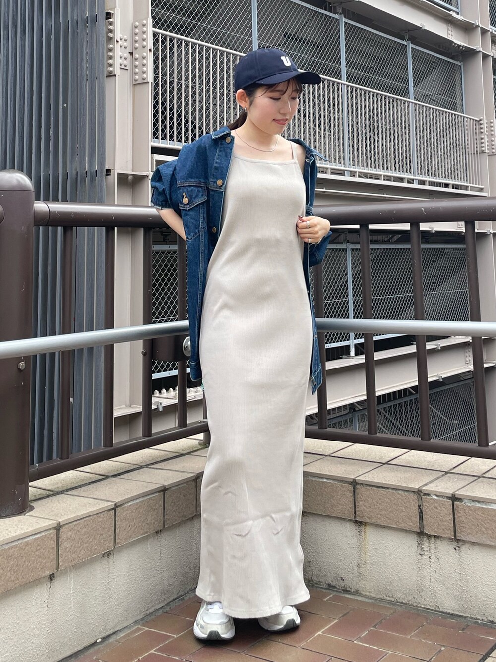 グレー系のワンピース、ブルー系のデニムジャケット、ブルー系のキャップを着用したレディースの夏コーディネートの8枚目の写真