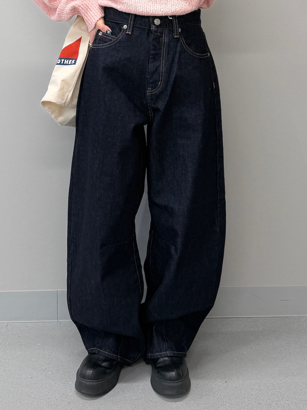 ブルー系のデニムパンツ、ブラック系のブーツ、ピンク系のニット/セーターを着用したレディースの冬コーディネートの7枚目の写真