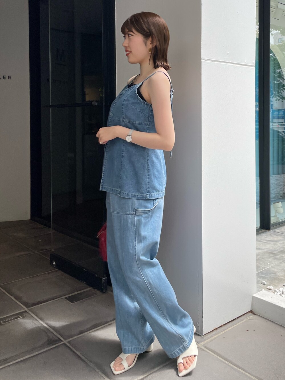 レッド系のハンドバッグ、ホワイト系のサンダル、ブルー系のキャミソールを着用したレディースの春コーディネートの2枚目の写真