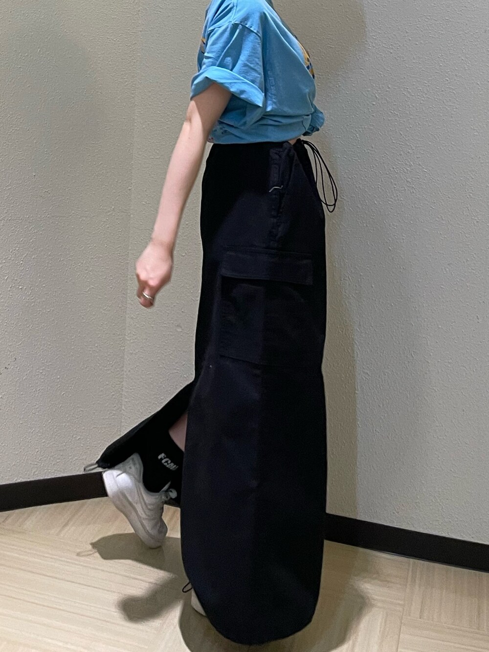 ブルー系のTシャツ/カットソー、ブラック系のスカート、ゴールド系のネックレスを着用したレディースの春コーディネートの7枚目の写真