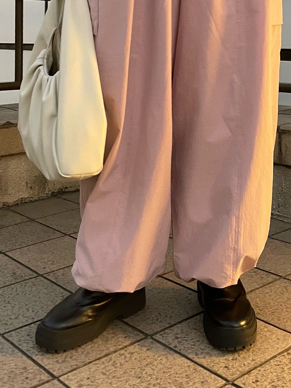 ピンク系のカーゴパンツ、ホワイト系のハンドバッグ、グレー系のニット/セーターを着用したレディースの冬コーディネートの7枚目の写真