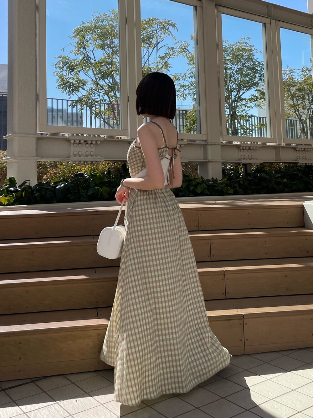 ホワイト系のハンドバッグ、グリーン系のワンピース、ブルー系のデニムジャケットを着用したレディースの冬コーディネートの6枚目の写真