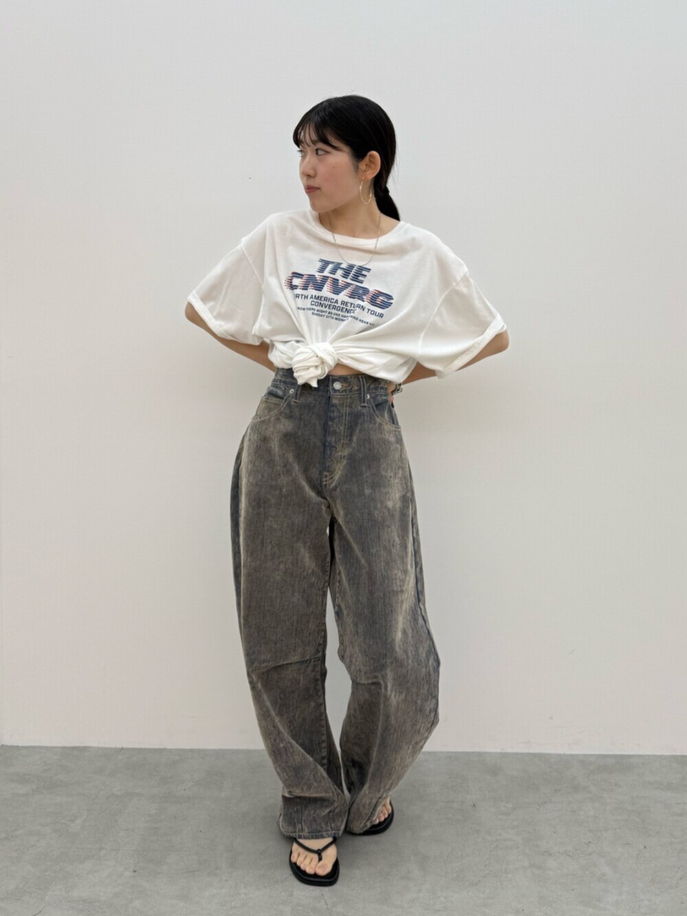 ブラック系のサンダル、ホワイト系のTシャツ/カットソー、ベージュ系のデニムパンツを着用したレディースの夏コーディネートの4枚目の写真