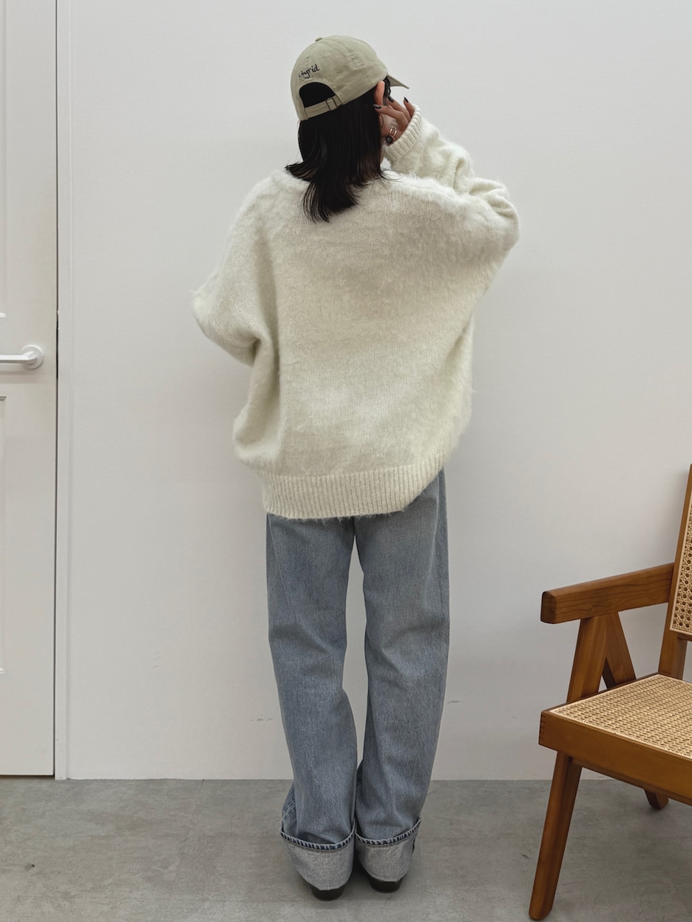 ホワイト系のニット/セーター、ブルー系のデニムパンツ、ブラウン系のブーツを着用したレディースの冬コーディネートの5枚目の写真