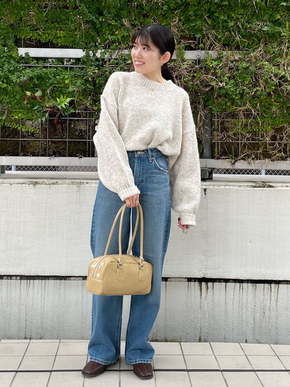 ブルー系のデニムパンツ、ブラウン系のブーツ、ホワイト系のニット/セーターを着用したレディースの秋コーディネートの7枚目の写真