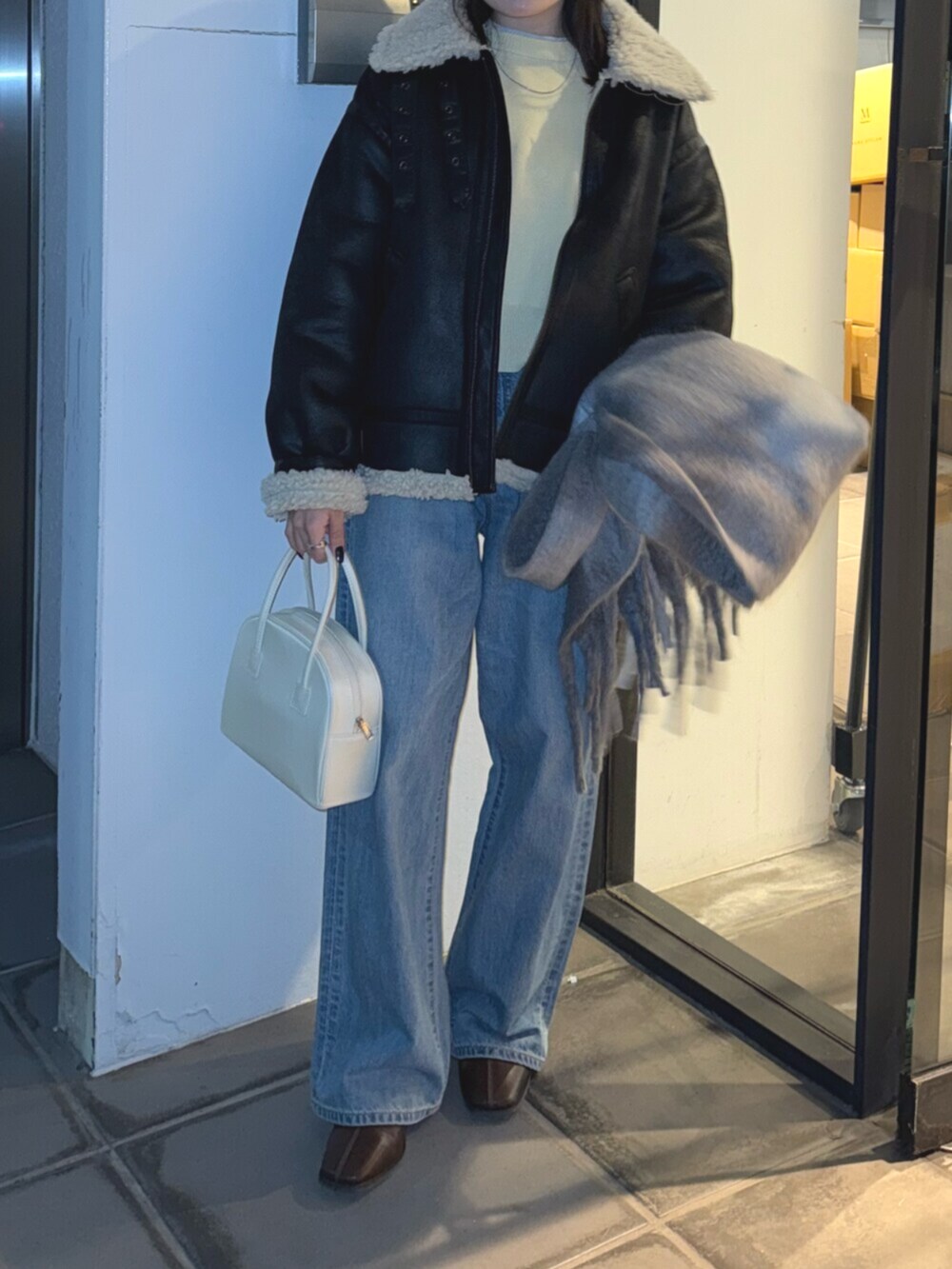 ブラウン系のブーツ、ブルー系のデニムパンツ、イエロー系のニット/セーターを着用したレディースの冬コーディネートの5枚目の写真