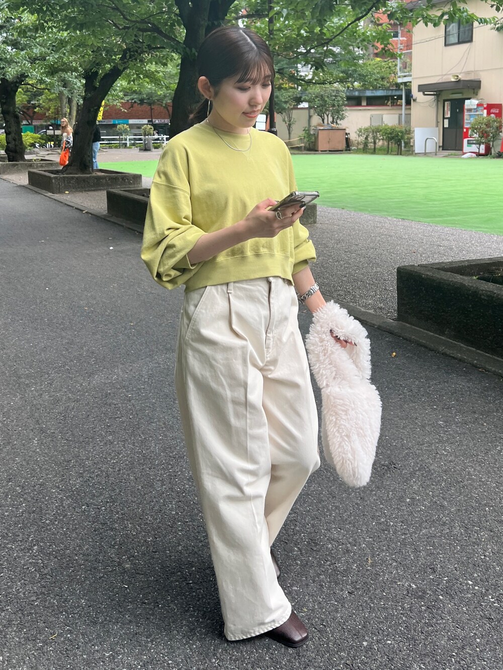 ホワイト系のデニムパンツ、ブラウン系のブーツ、グリーン系のスウェットを着用したレディースの秋コーディネートの2枚目の写真