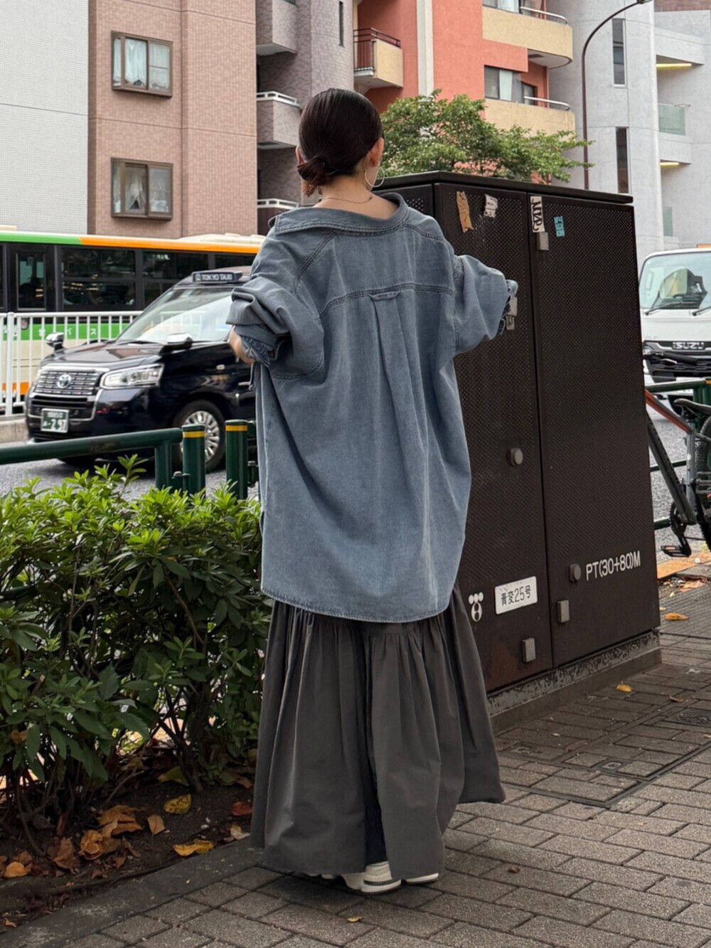 グレー系のスカート、ブルー系のシャツ/ブラウスを着用したレディースの秋コーディネートの2枚目の写真