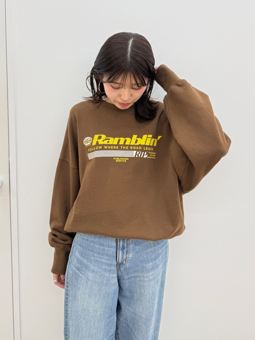 ブルー系のデニムパンツ、ブラック系のブーツ、ブラウン系のスウェットを着用したレディースの秋コーディネートの7枚目の写真