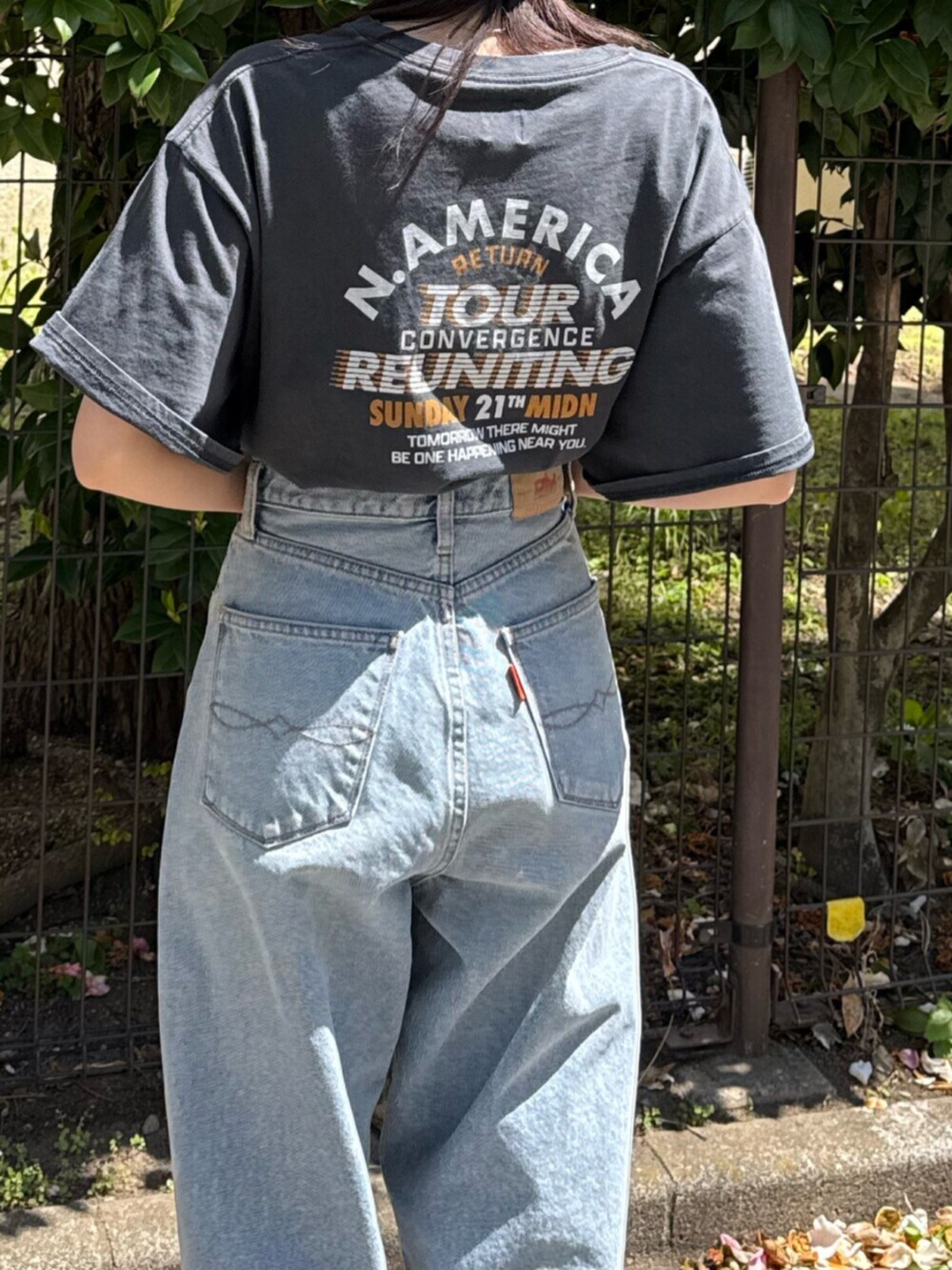 ブルー系のデニムパンツ、ブラック系のサンダル、グレー系のTシャツ/カットソーを着用したレディースの春コーディネートの9枚目の写真