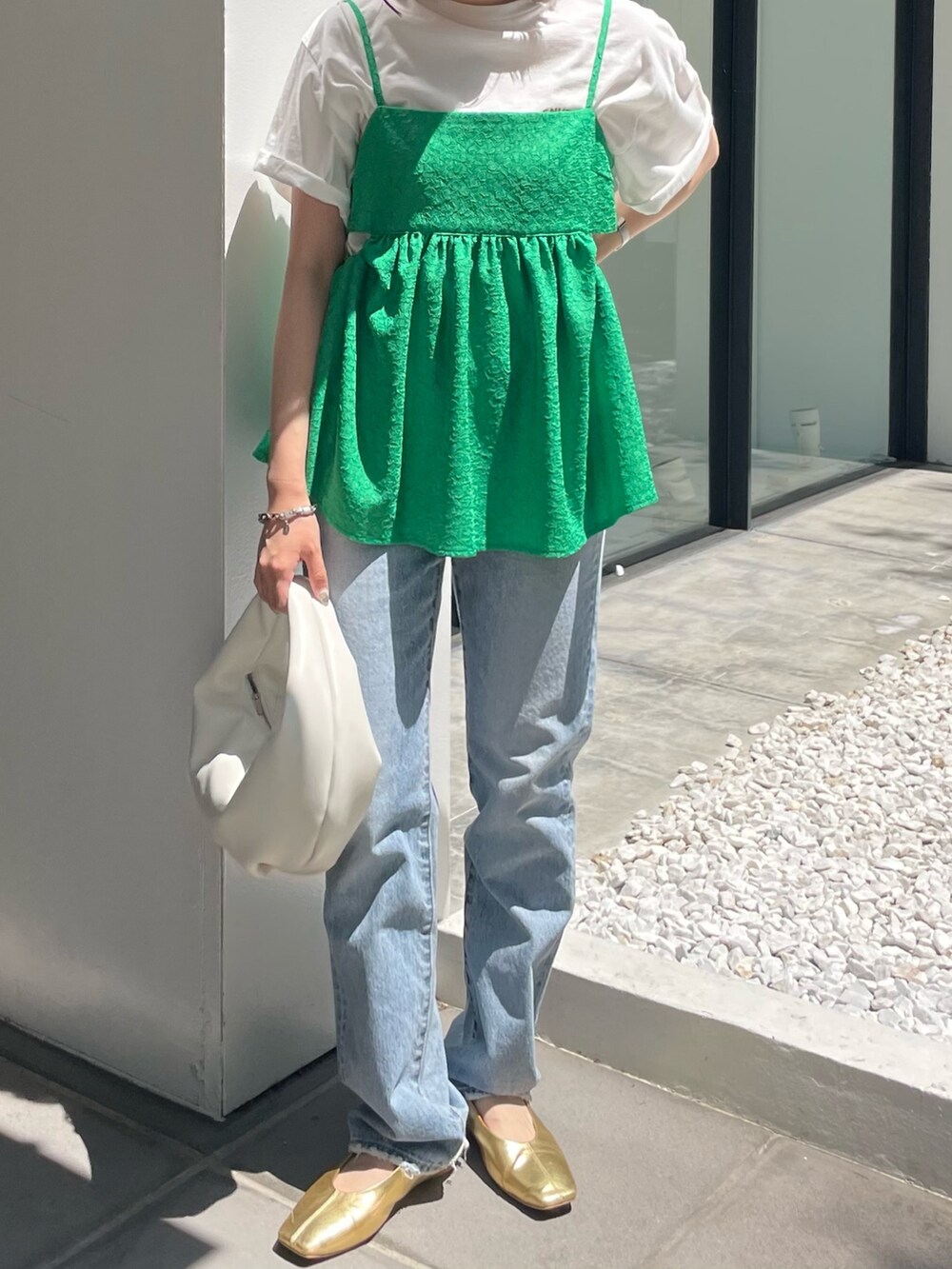 ホワイト系のハンドバッグ、ブルー系のデニムパンツ、グリーン系のシャツ/ブラウスを着用したレディースの春コーディネートの2枚目の写真