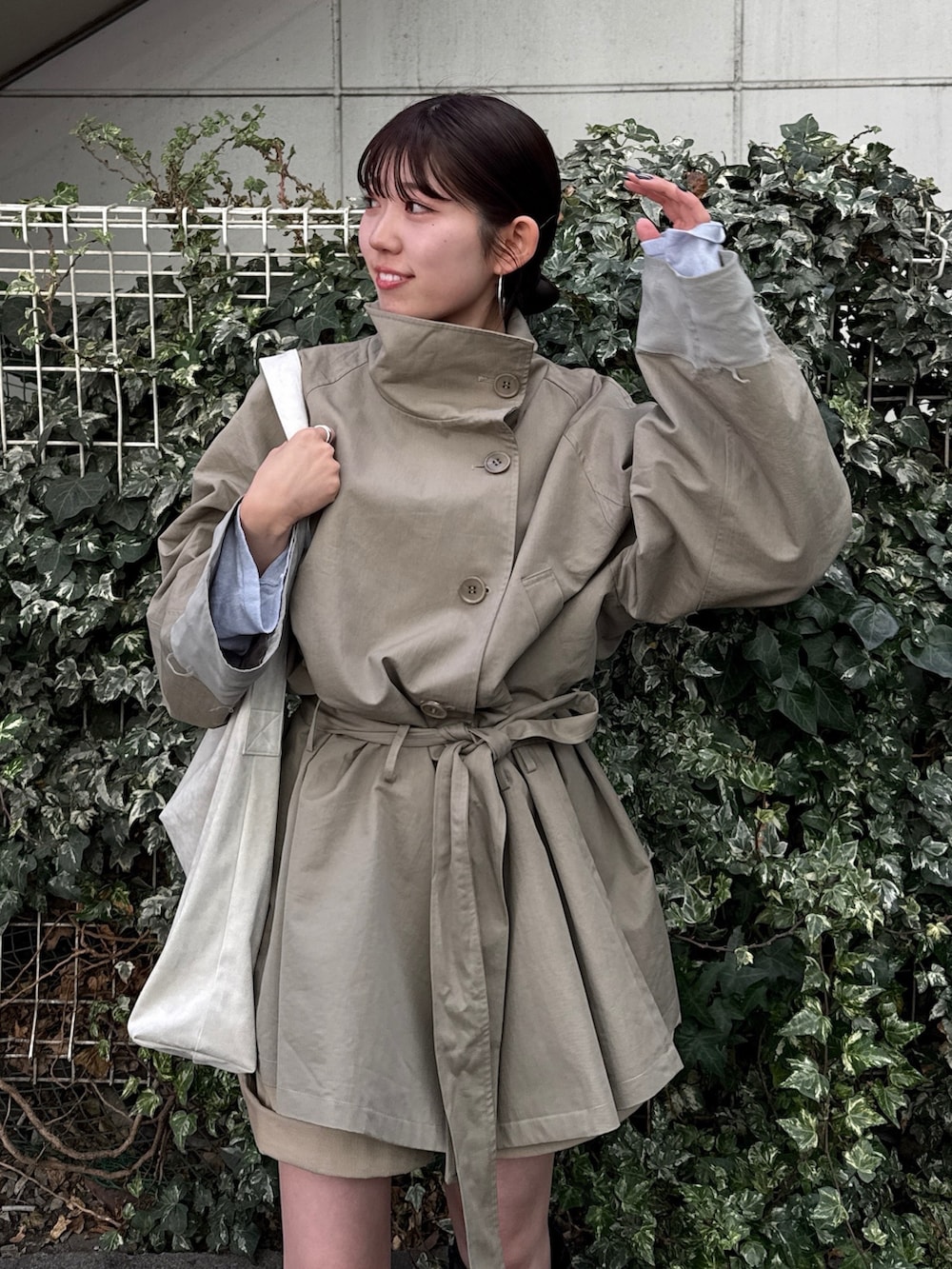 グリーン系のトレンチコート、ベージュ系のその他パンツを着用したレディースの冬コーディネートの2枚目の写真