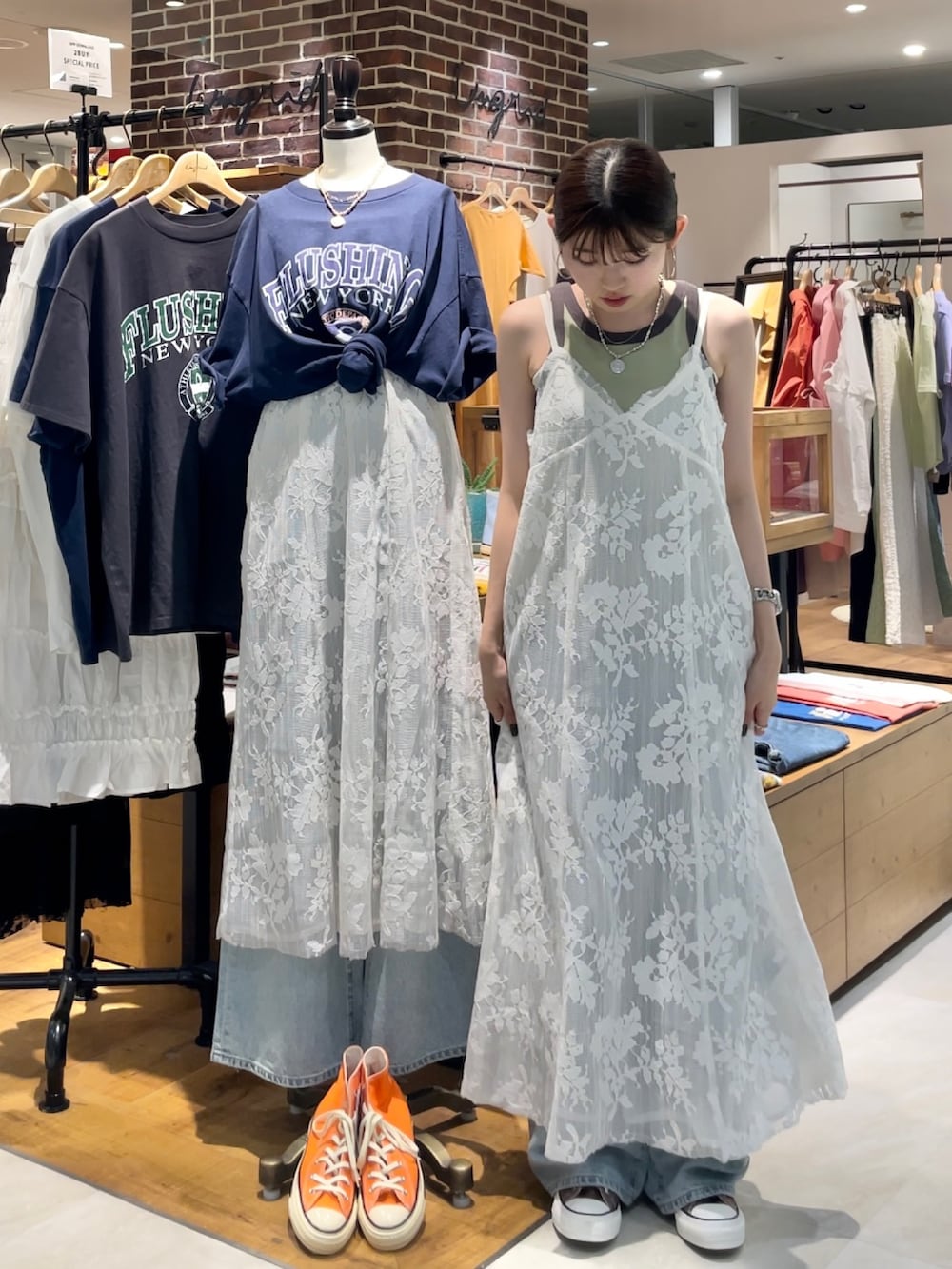 グリーン系のタンクトップ、ブルー系のデニムパンツ、ホワイト系のワンピースを着用したレディースの夏コーディネートの6枚目の写真