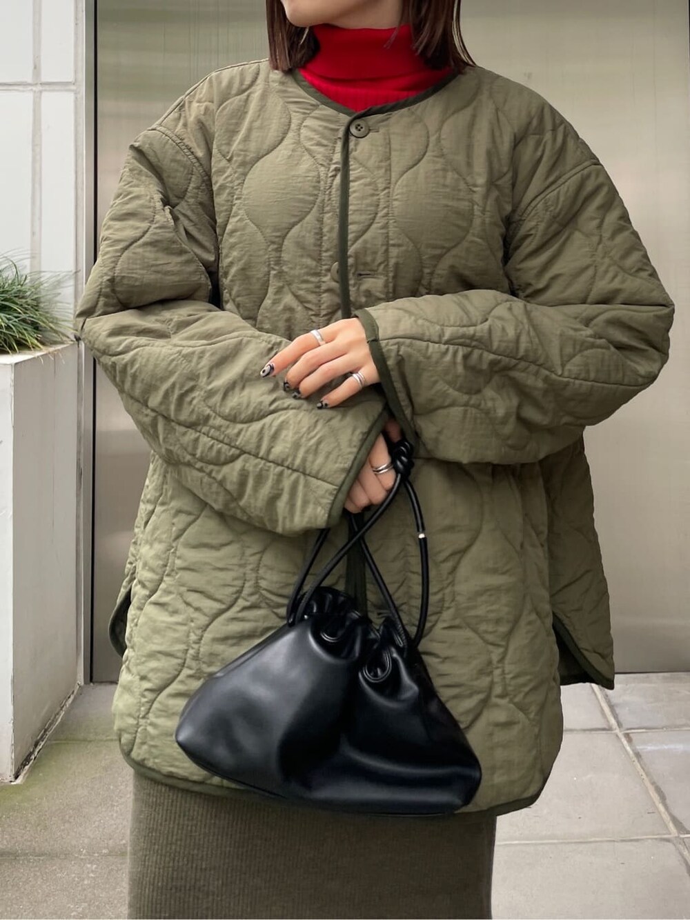 ブラック系のブーツ、グリーン系のブルゾン、レッド系のニット/セーターを着用したレディースの秋コーディネートの5枚目の写真