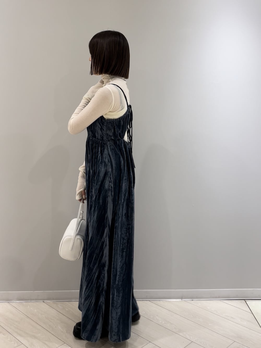 ホワイト系のハンドバッグ、ホワイト系のTシャツ/カットソー、ブルー系のワンピースを着用したレディースの冬コーディネートの2枚目の写真