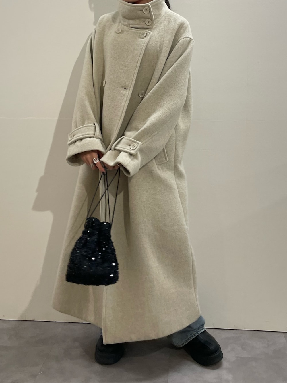 ブルー系のデニムパンツ、ブラック系のブーツ、レッド系のニット/セーターを着用したレディースの冬コーディネートの5枚目の写真