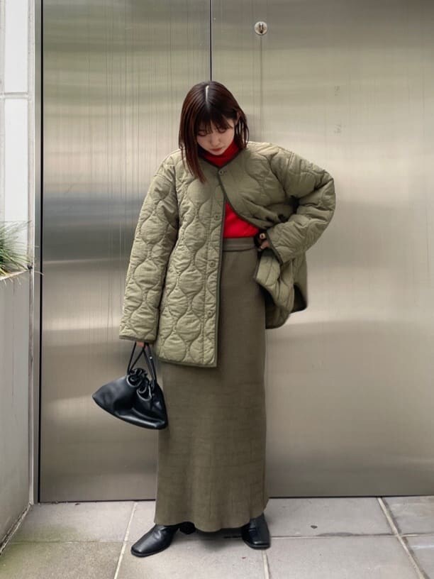 ブラック系のブーツ、グリーン系のブルゾン、レッド系のニット/セーターを着用したレディースの秋コーディネートの2枚目の写真