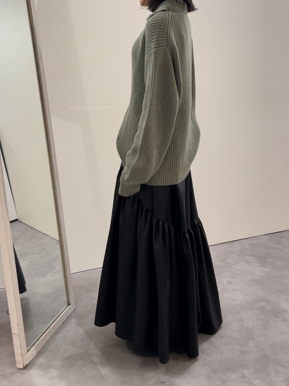 ブラック系のブーツ、ブラック系のスカート、グレー系のニット/セーターを着用したレディースの冬コーディネートの7枚目の写真