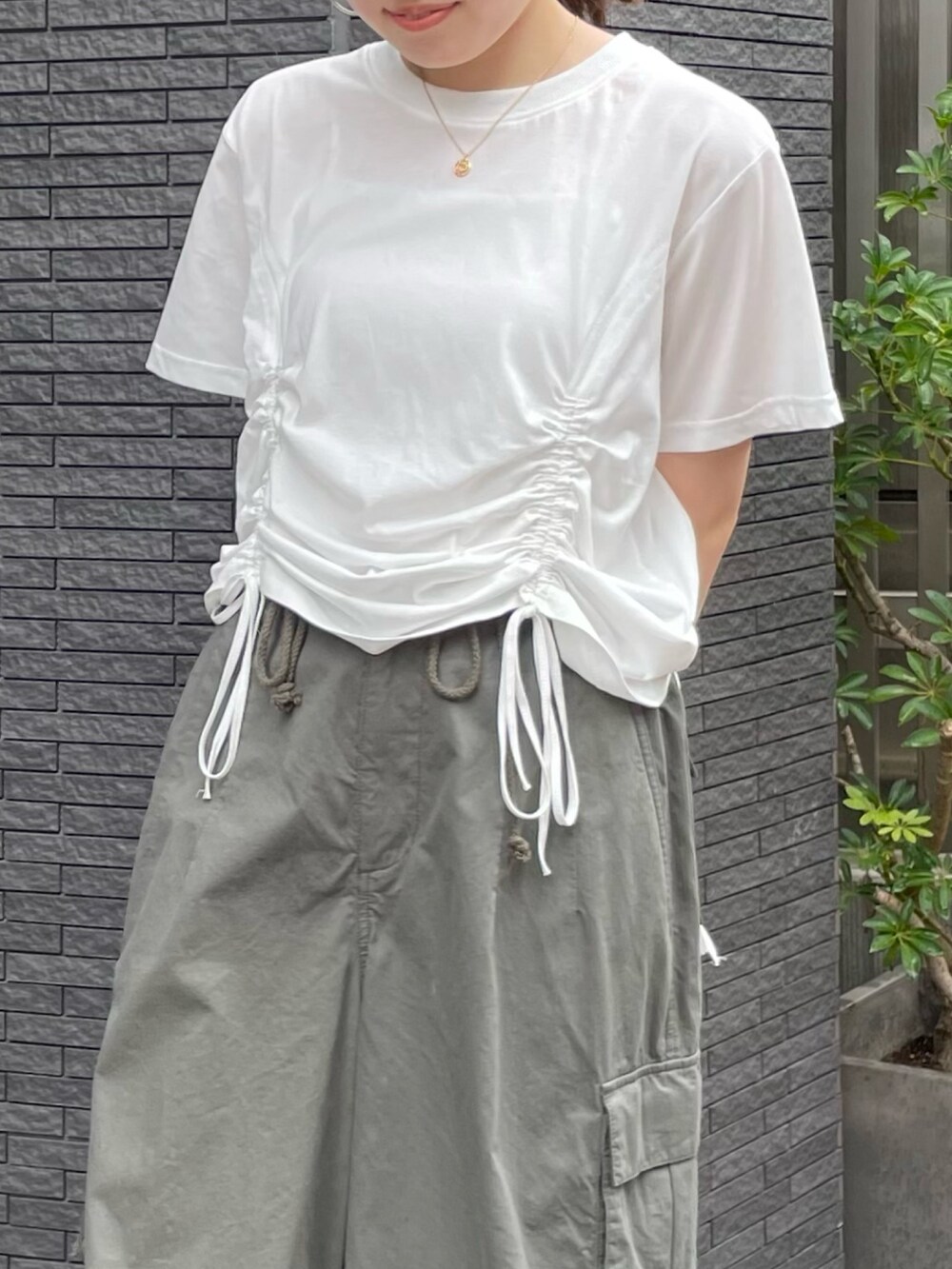 ホワイト系のTシャツ/カットソー、ブラック系のサンダル、グリーン系のカーゴパンツを着用したレディースの夏コーディネートの7枚目の写真