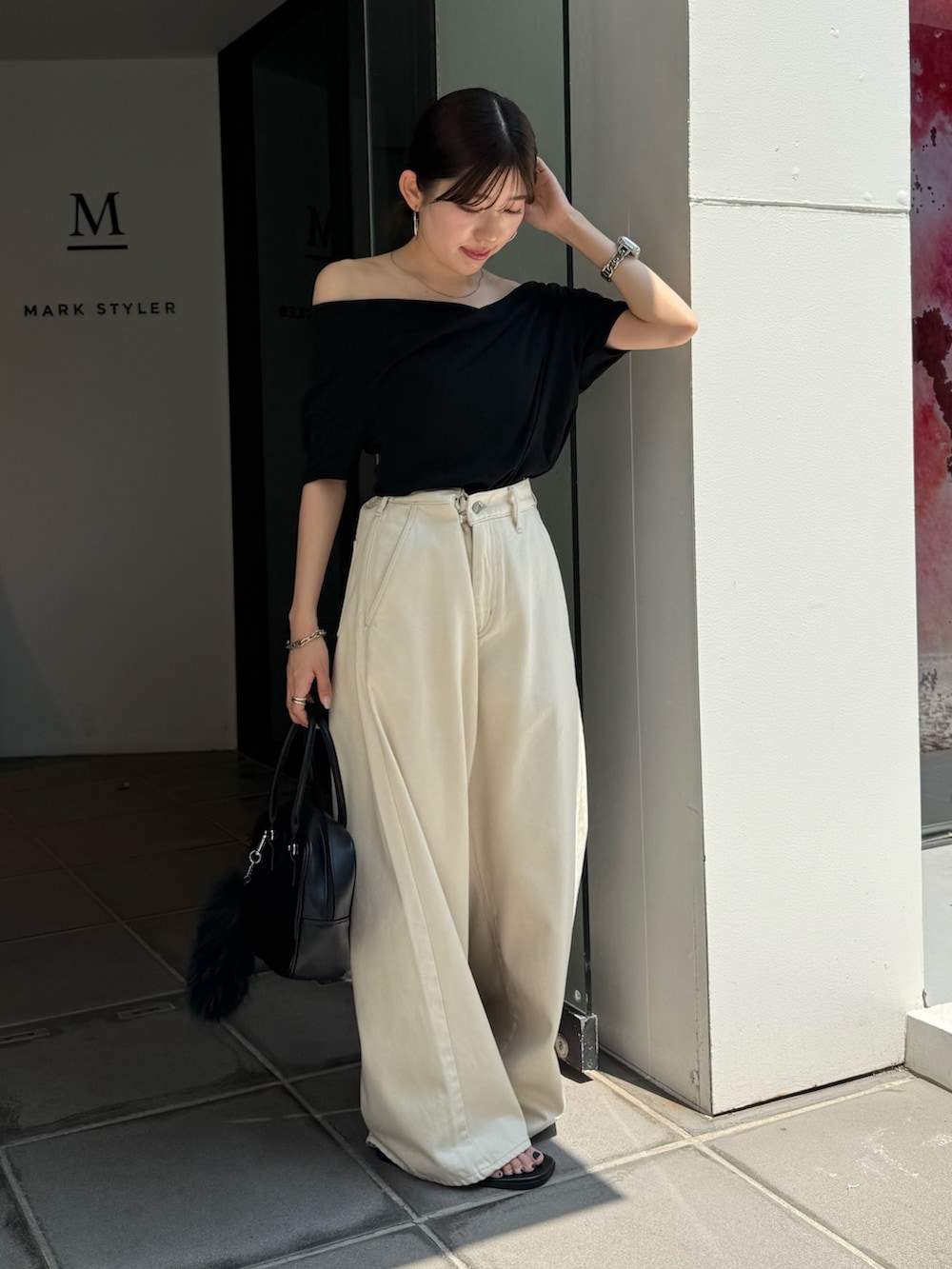 ブラック系のTシャツ/カットソー、ブラック系のサンダル、ブラック系のハンドバッグを着用したレディースの夏コーディネートの2枚目の写真