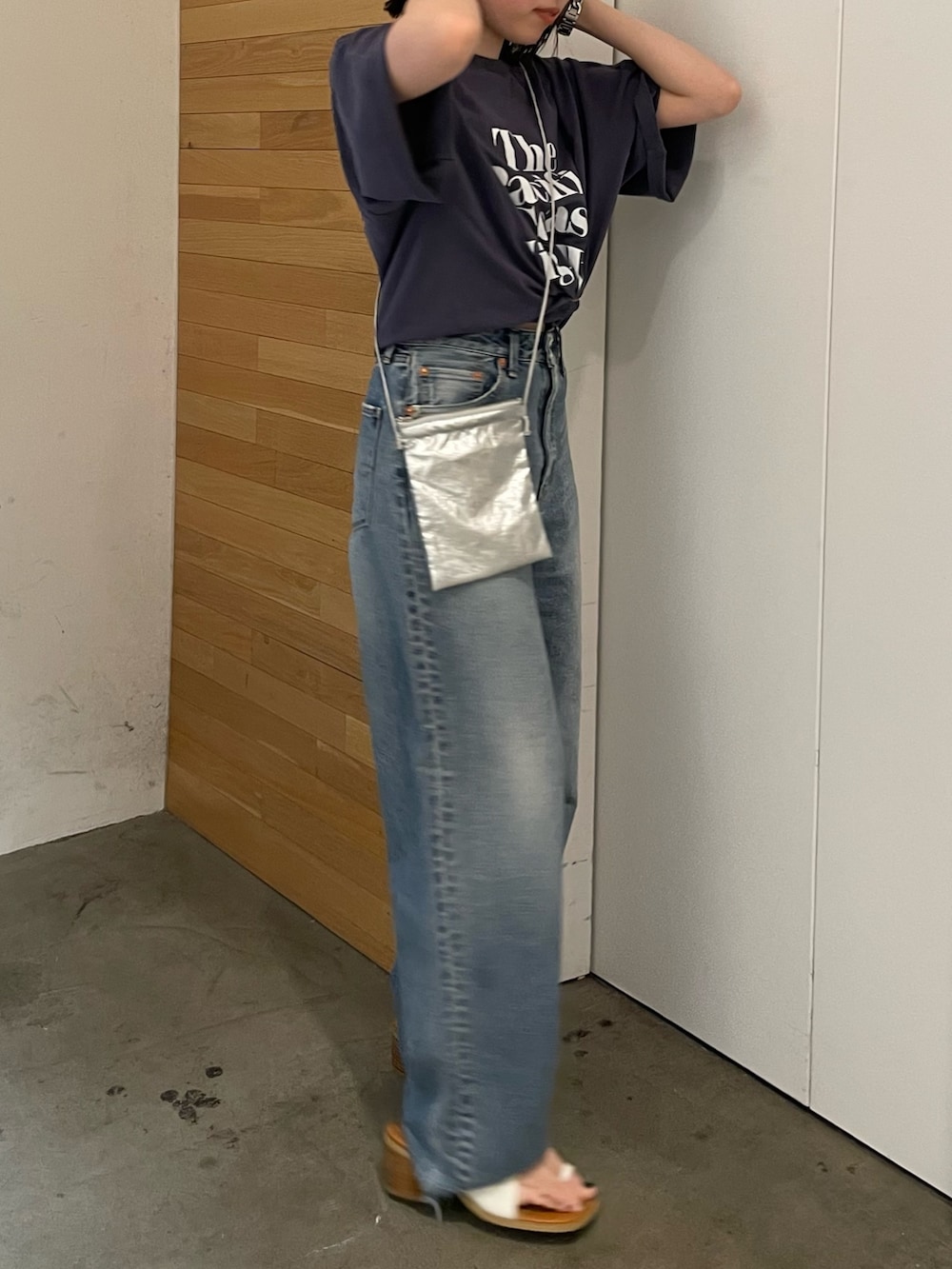 ホワイト系のサンダル、ブルー系のデニムパンツ、シルバー系のショルダーバッグを着用したレディースの春コーディネートの3枚目の写真